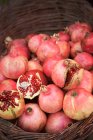 Pomegranates pile in basket at market stall — Stock Photo
