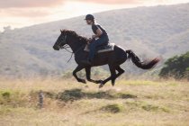 Mann reitet Pferd in ländlicher Landschaft — Stockfoto