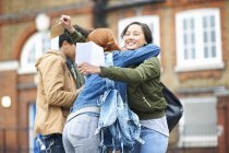 Young adult college students congratulating each others exam results on campus — Stock Photo