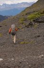Турист ходит с палками на скалистых холмах — стоковое фото