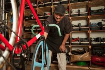 Mechanic working in bicycle shop — Stock Photo
