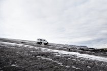 Vierrad-LKW geparkt in eisiger schwarzer Landschaft, Island — Stockfoto