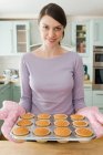 Femme tenant un plateau avec des cupcakes — Photo de stock