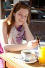 Young woman sitting in a cafe — Stock Photo