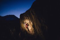 Junger Mann Felsklettern in der Nacht, Buttermilch-Felsbrocken, Bischof, Kalifornien, USA — Stockfoto