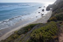 Piccola spiaggia di sabbia sulla costa rocciosa — Foto stock