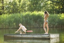 Молодая пара стоит на платформе в реке — стоковое фото