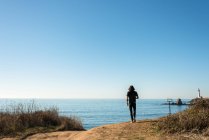 Un hombre camina por la playa en la costa del mar. - foto de stock