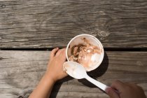 Young girl eating bowl of ice cream with spoon — Stock Photo
