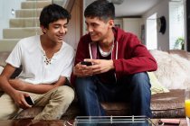 Хлопчики-підлітки дивляться на мобільний телефон — стокове фото