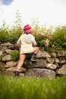 Girl climbing stone wall — Stock Photo