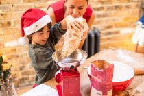 Мать и сын пекут рождественское печенье дома — стоковое фото