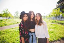 Portrait of three young female friends in park — Stock Photo