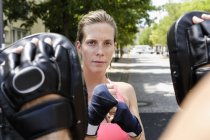 Mulher boxeadora e personal trainer exercitando no parque — Fotografia de Stock