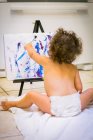 Little girl painting in kitchen — Stock Photo