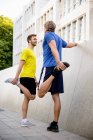 Two men stretching hamstrings — Stock Photo