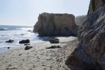 Небольшой песчаный пляж на скалистом побережье — стоковое фото