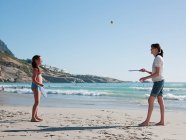 Madre e figlia che giocano a paddleball sulla spiaggia — Foto stock