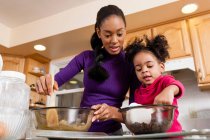 Mother and daughter mixing cookie dough — Stock Photo