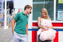 Teenage couple at pier with teddy bear — Stock Photo