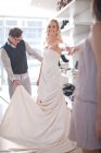 Жінка намагається на весільній сукні — стокове фото