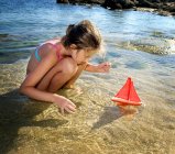 Giovane ragazza con una barca a vela giocattolo — Foto stock