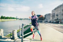 Mitte erwachsene Läuferin läuft am Flussufer entlang — Stockfoto