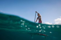 Woman paddleboarding on ocean — Stock Photo