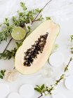 Aromatische Papaya, Blüten und Limetten — Stockfoto