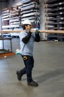 Trabalhador que transporta tubos em fábrica de metal — Fotografia de Stock