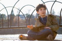 Мальчик сидит со скрещенными ногами в наушниках — стоковое фото