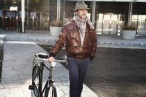Mitte erwachsener Mann zu Fuß mit Fahrrad in der Stadt — Stockfoto