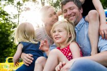 Genitori felici e tre figlie che condividono picnic in famiglia nel parco — Foto stock