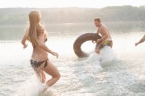 Amigos que se divertem com anel inflável no rio — Fotografia de Stock