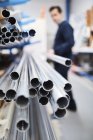 Arbeiter entfernt Metallstange aus Regal in Rollladen-Fabrik — Stockfoto