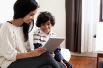 Mutter und Sohn nutzen digitales Tablet im Wohnzimmer — Stockfoto