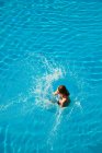 Jeune femme sautant dans la piscine — Photo de stock