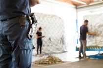 Guardia de seguridad vigilando trabajadores en almacén de carga aérea - foto de stock