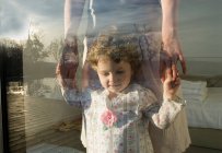 Mother and daughter in bedroom at window with reflection — Stock Photo