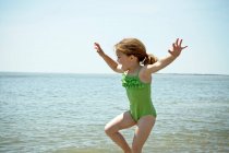 Lächelndes Mädchen spielt am Strand — Stockfoto