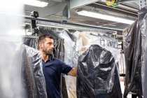 Male warehouse worker doing garment stock take in distribution warehouse — Stock Photo