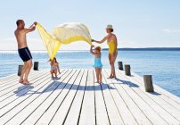 Parents and two young girls playing on pier — Stock Photo