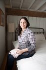 Expectant mother sitting on bed — Stock Photo