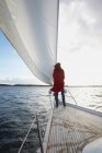 Woman standing by sail on yacht — Stock Photo