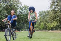 Front view of mother and son riding on bicycles smiling — Stock Photo
