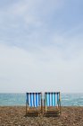 Два пустых шезлонга на пляже при солнечном свете — стоковое фото