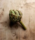 Geren alcachofra vegetal na superfície de madeira — Fotografia de Stock