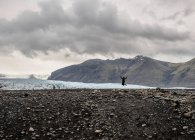 Silhouette d'une touriste qui saute en plein air devant un glacier, Skaftafell, Islande — Photo de stock