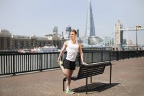 Runner stretching on riverfront, Wapping, London — Stock Photo