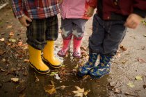 Tre bambini che indossano stivali wellington — Foto stock